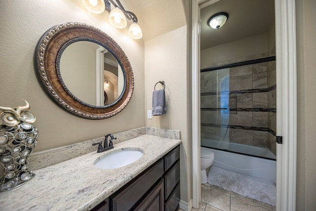 full bathroom with tile patterned floors, vanity, enclosed tub / shower combo, and toilet