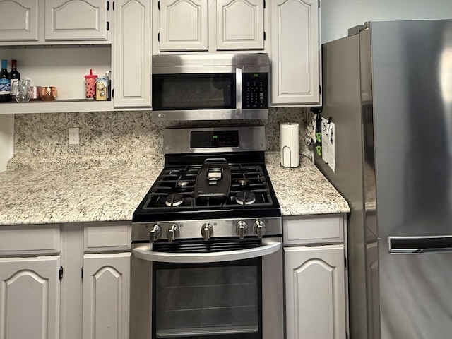 2204 Regal Pl, Midland, TX 79707 - kitchen featuring stainless steel appliances, backsplash, and light stone countertops