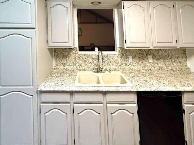 2204 Regal Pl, Midland, TX 79707 - kitchen featuring black dishwasher, a sink, tasteful backsplash, and white cabinets