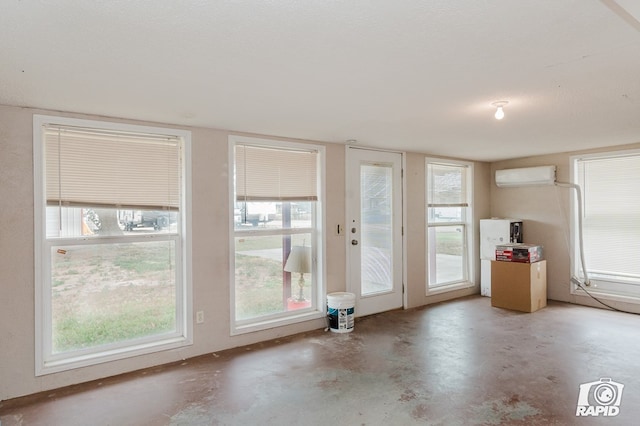 entryway with a healthy amount of sunlight, an AC wall unit, and a textured ceiling