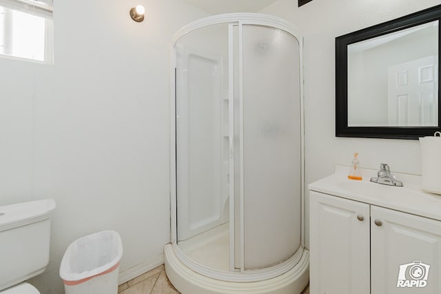 bathroom with tile patterned flooring, vanity, toilet, and a shower with shower door