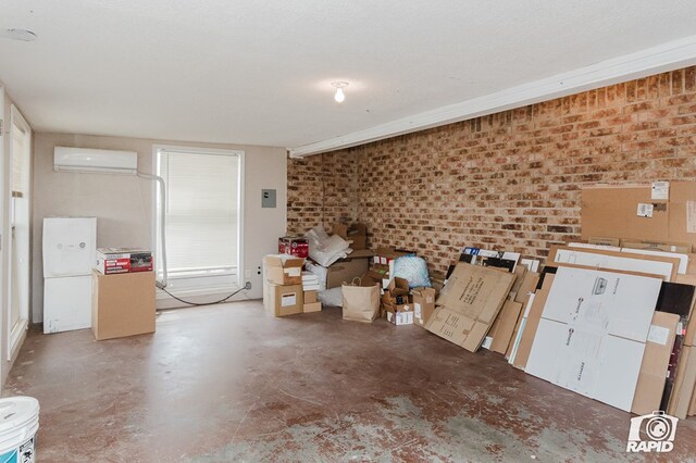 misc room with an AC wall unit, concrete floors, and brick wall