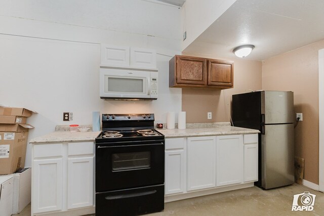 kitchen with stainless steel fridge, white cabinetry, black electric range, and light stone counters