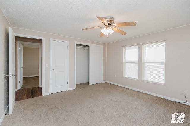 unfurnished bedroom with a textured ceiling, ceiling fan, and light carpet