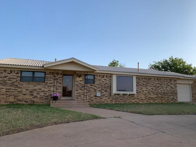 ranch-style home with a garage and a front lawn