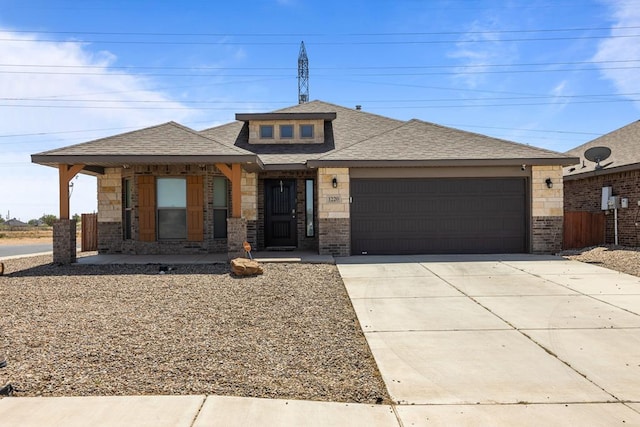 1220 Wrangler Ln, Midland, TX 79705 - prairie-style home with a shingled roof, a garage, driveway, and brick siding