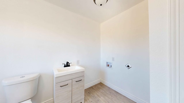 bathroom with toilet, hardwood / wood-style flooring, vaulted ceiling, and vanity