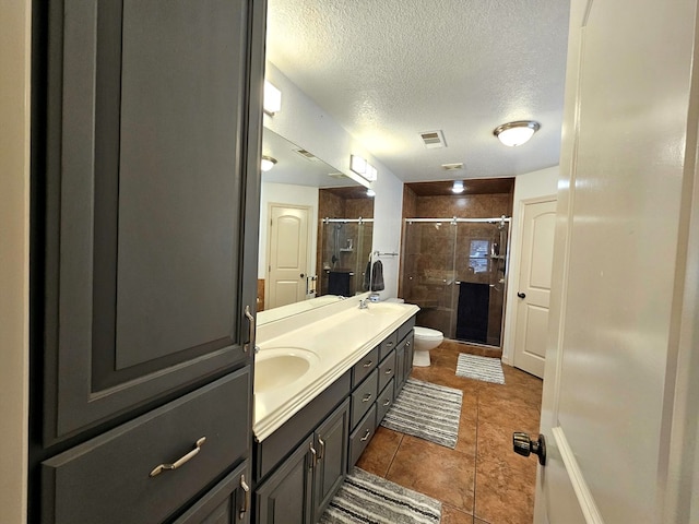 916-B Bronstad Dr, Andrews, TX 79714 - bathroom with double vanity, a stall shower, a textured ceiling, and tile patterned flooring