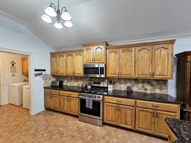 916-B Bronstad Dr, Andrews, TX 79714 - kitchen with appliances with stainless steel finishes, washing machine and dryer, vaulted ceiling, tasteful backsplash, and brown cabinetry