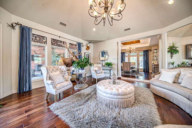 living room with ornate columns, a chandelier, dark wood-type flooring, and lofted ceiling