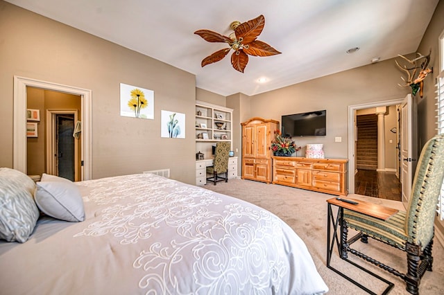 carpeted bedroom with ceiling fan and ensuite bath