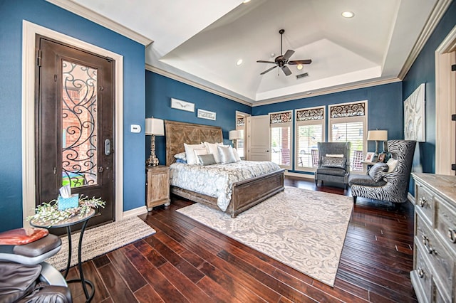 bedroom featuring ceiling fan, a raised ceiling, ornamental molding, and dark wood-type flooring