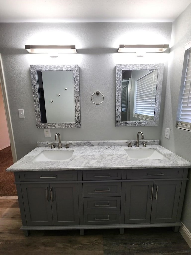 4732 Harvard Ave, Midland, TX 79703 - bathroom featuring double vanity, wood finished floors, and baseboards