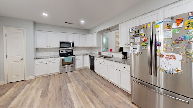 4732 Harvard Ave, Midland, TX 79703 - kitchen with stainless steel appliances, a sink, light wood-style flooring, decorative backsplash, and recessed lighting