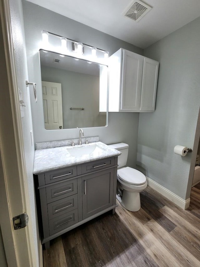 4732 Harvard Ave, Midland, TX 79703 - bathroom featuring toilet, vanity, wood finished floors, and baseboards