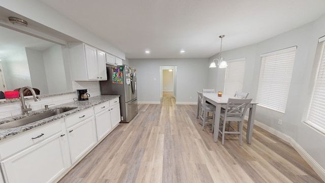 4732 Harvard Ave, Midland, TX 79703 - kitchen with a sink, freestanding refrigerator, white cabinets, light wood-style floors, and recessed lighting