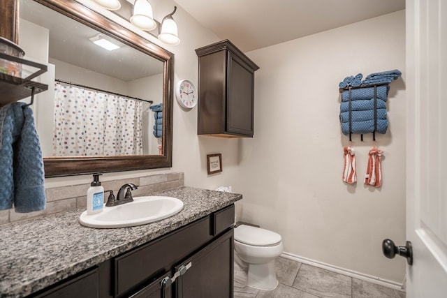 full bathroom with toilet, curtained shower, vanity, and baseboards