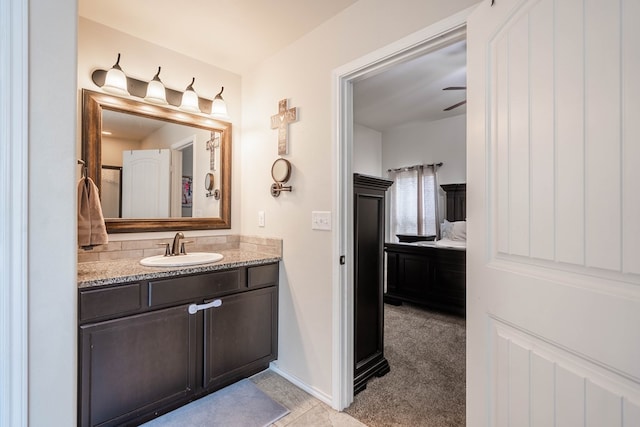 ensuite bathroom featuring baseboards, tile patterned flooring, ensuite bathroom, and vanity