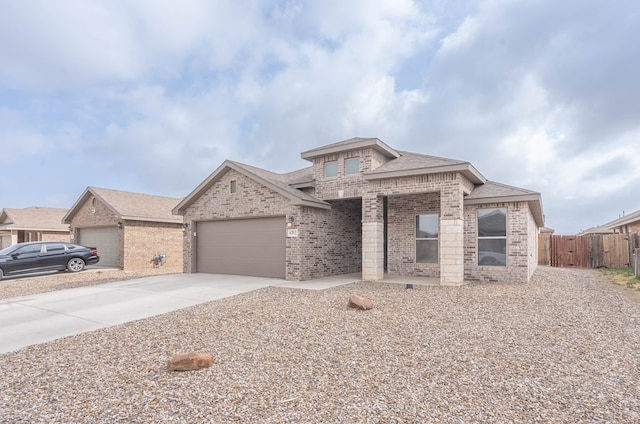 view of front of home featuring a garage, brick siding, fence, and driveway