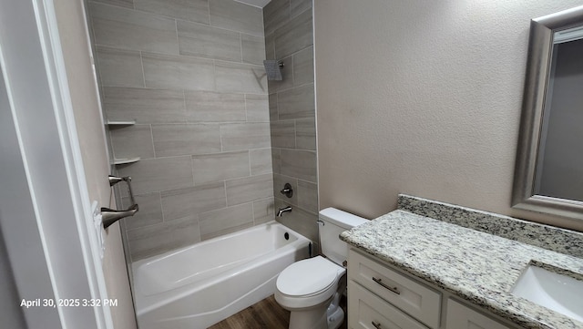 1104 Osprey Dr, Midland, TX 79706 - bathroom with toilet, shower / tub combination, wood finished floors, vanity, and a textured wall