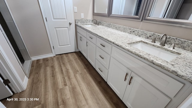 1104 Osprey Dr, Midland, TX 79706 - full bathroom featuring double vanity, a shower, wood finished floors, and a sink