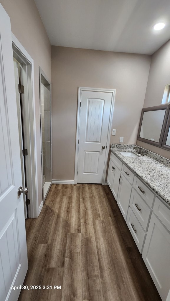 1104 Osprey Dr, Midland, TX 79706 - bathroom with a tile shower, vanity, and wood finished floors