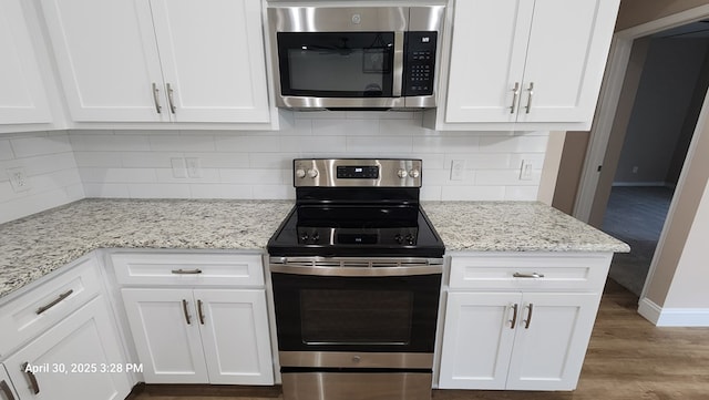 1104 Osprey Dr, Midland, TX 79706 - kitchen featuring white cabinetry, stainless steel appliances, baseboards, and tasteful backsplash