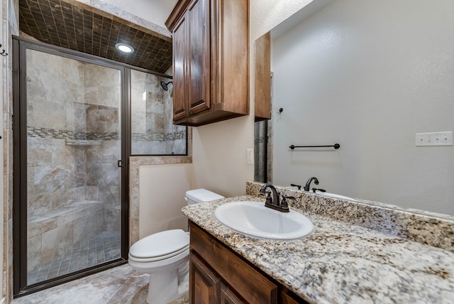 bathroom with walk in shower, vanity, and toilet