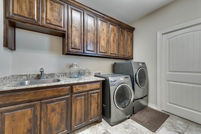 washroom with cabinets, washer and clothes dryer, and sink