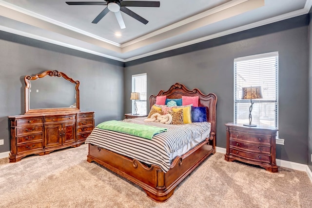 carpeted bedroom featuring a raised ceiling, baseboards, and ornamental molding