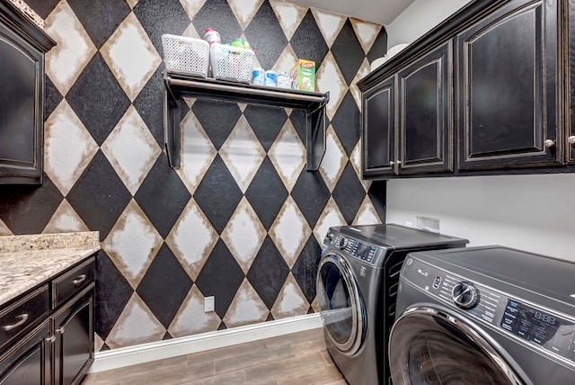 laundry room with cabinet space, light wood-style floors, and separate washer and dryer