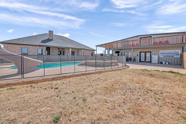 view of swimming pool with a patio, a fenced in pool, fence, a water slide, and french doors