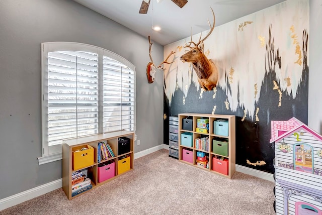 recreation room featuring carpet flooring, baseboards, and ceiling fan