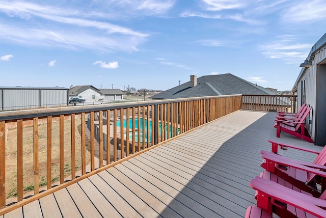 deck with a swimming pool, a fenced backyard, and a residential view