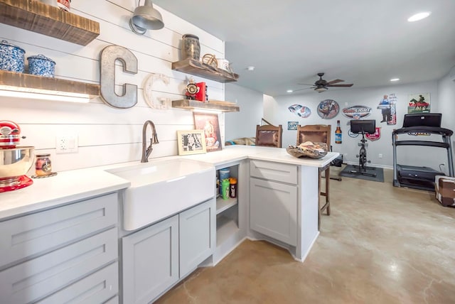 kitchen with open shelves, concrete floors, recessed lighting, a peninsula, and a sink