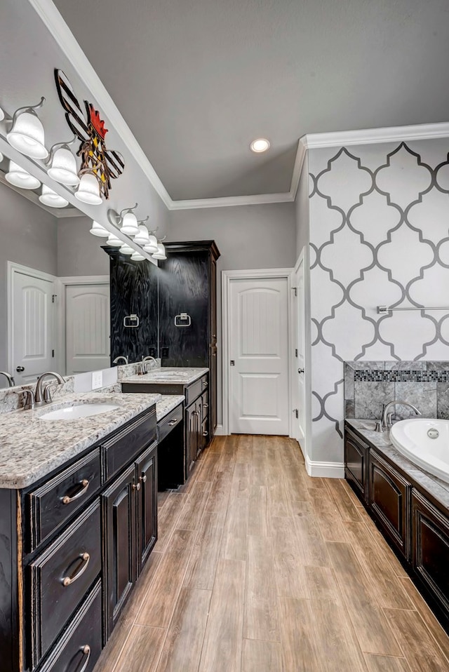 full bath with crown molding, two vanities, wood finished floors, and a sink