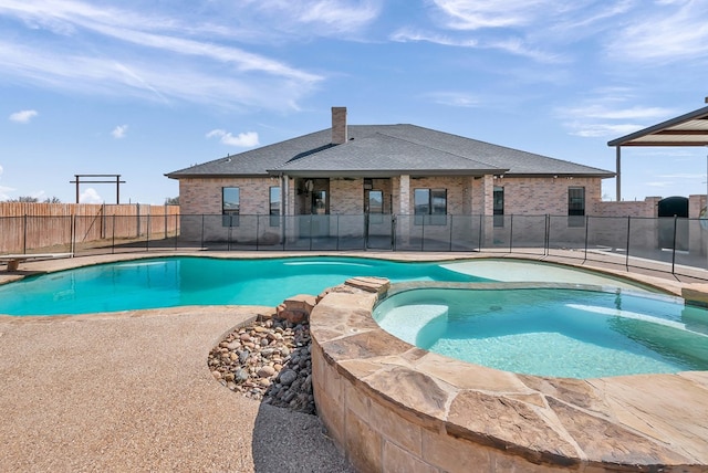 view of swimming pool with a patio area, a diving board, a pool with connected hot tub, and fence