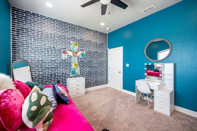 carpeted bedroom with visible vents, brick wall, an accent wall, and baseboards