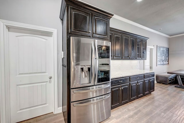 kitchen with crown molding, light wood-style floors, stainless steel fridge, and light stone countertops