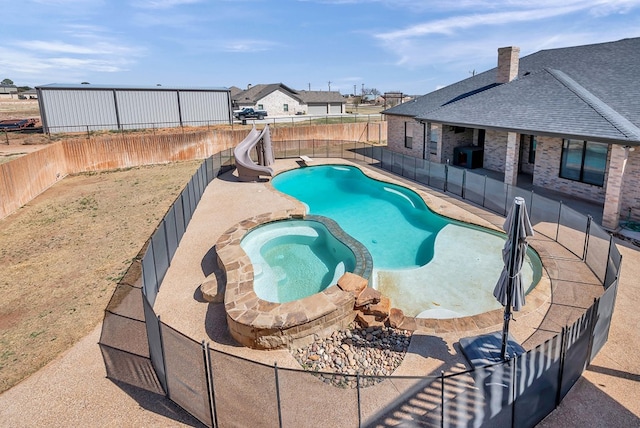 view of swimming pool featuring a pool with connected hot tub, a patio area, a fenced backyard, and a water slide