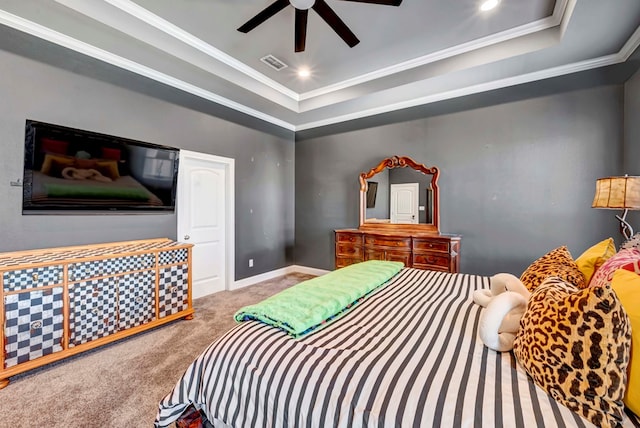 carpeted bedroom with visible vents, a raised ceiling, baseboards, and crown molding