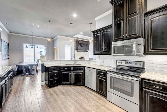 kitchen featuring crown molding, wood tiled floor, decorative backsplash, appliances with stainless steel finishes, and a sink