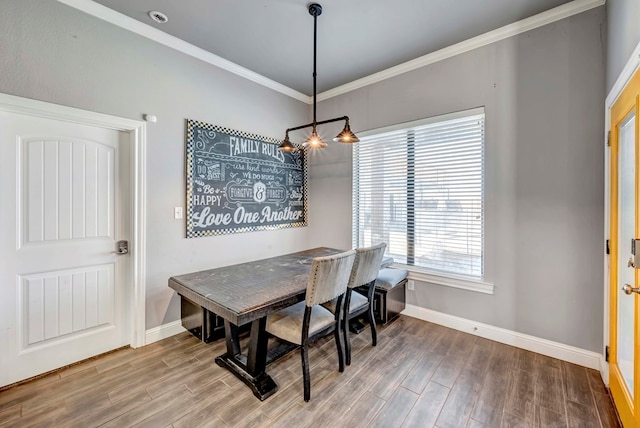 dining area with wood finished floors, baseboards, and ornamental molding