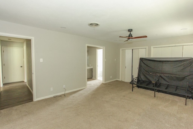 carpeted bedroom featuring ensuite bathroom and ceiling fan