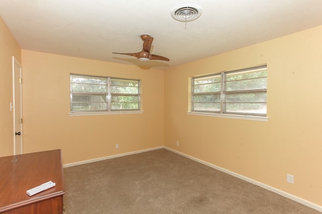 spare room with ceiling fan and carpet