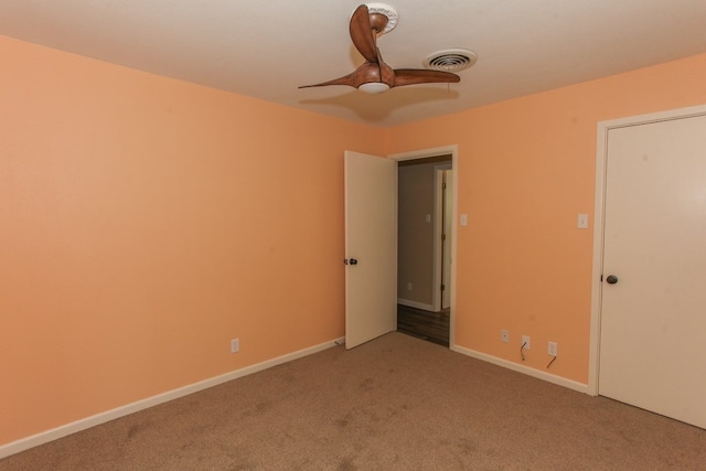 carpeted spare room with ceiling fan