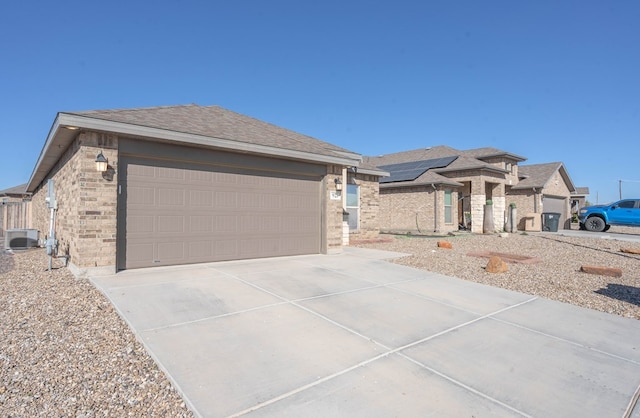 view of front of property featuring solar panels, a garage, and central air condition unit