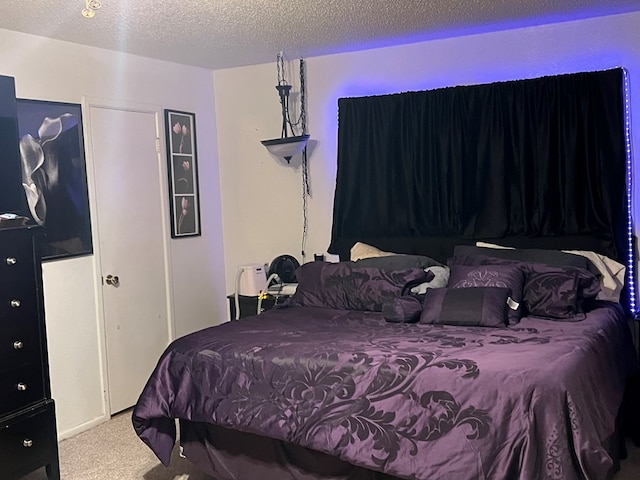 bedroom featuring carpet and a textured ceiling