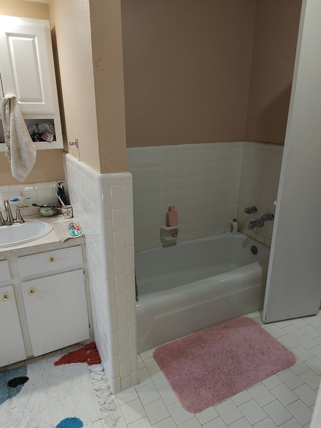 bathroom featuring tile patterned floors, vanity, and a bath