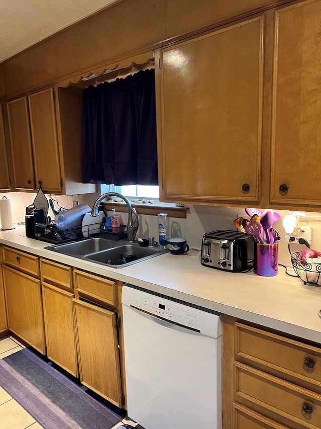 kitchen with white dishwasher, light tile patterned floors, and sink